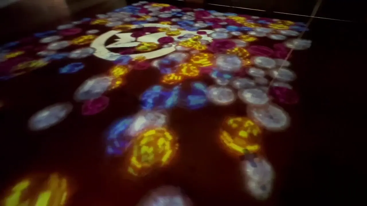 Close view of colorful circles and a large monochrome graphic projected onto the floor.