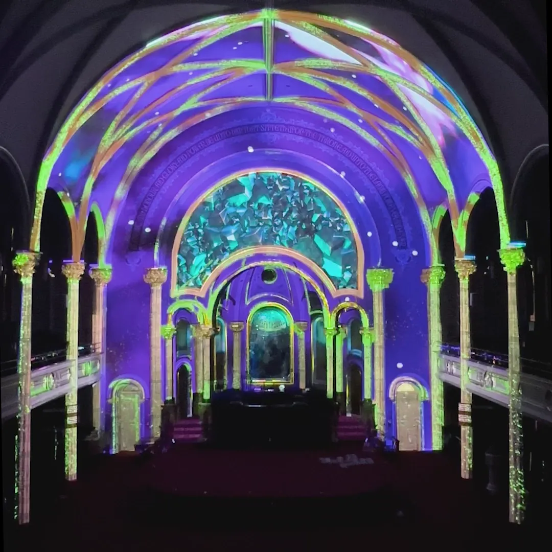 Blue and green projected patterns filling successive arches.