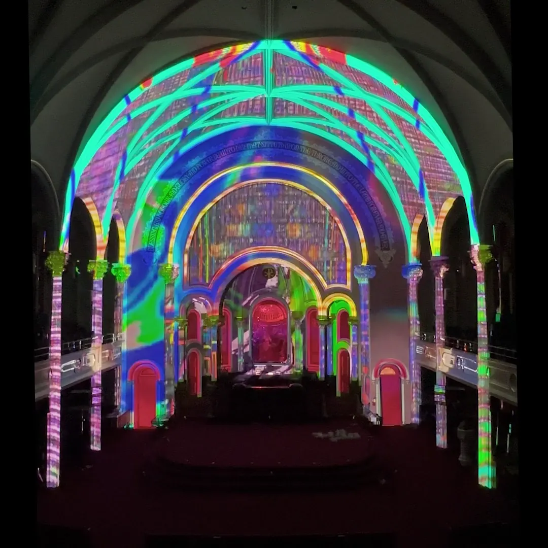 Multicolored projected graphics across the ceiling and arches.