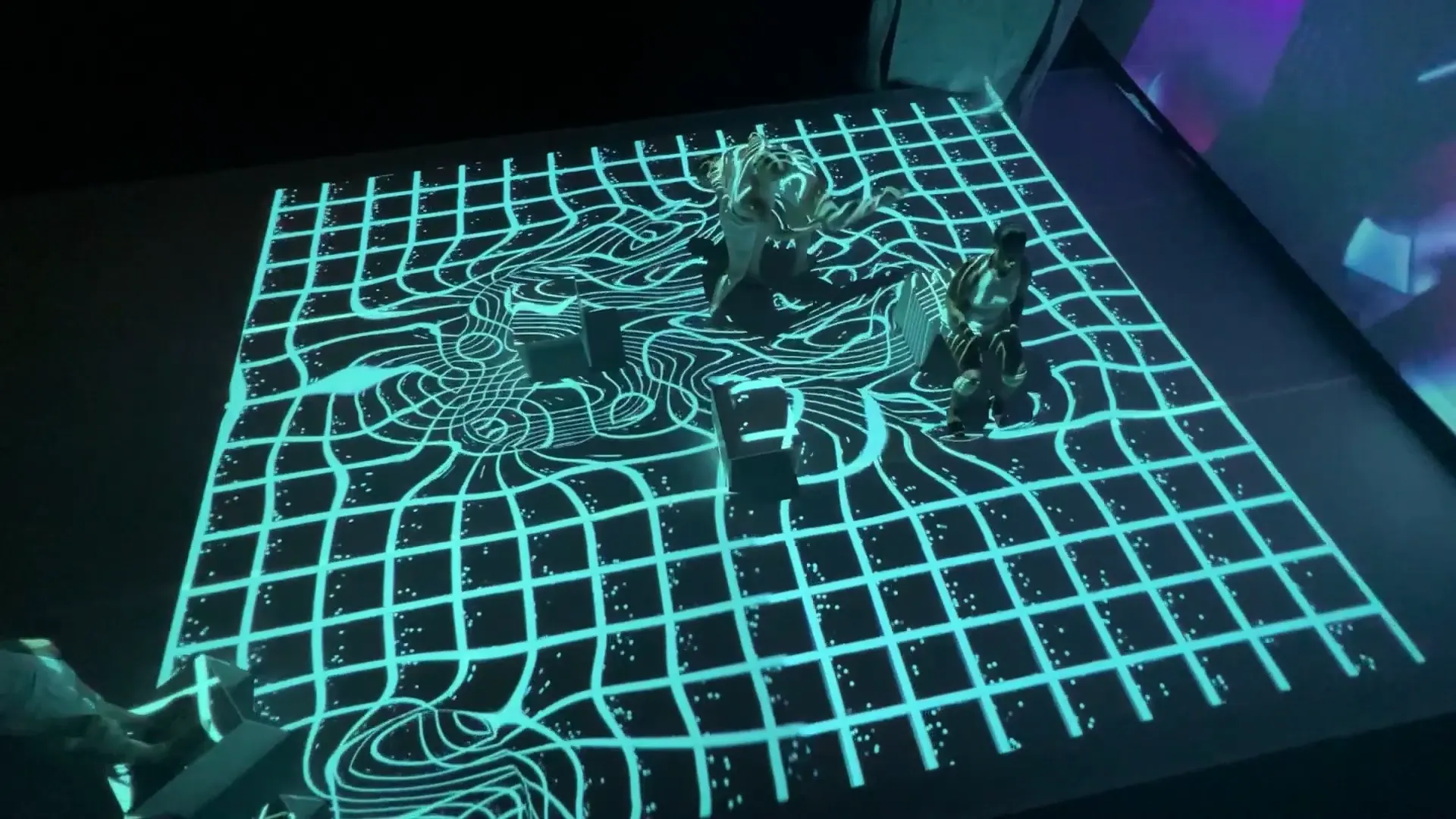 Performers surrounded by cyan contour lines projected onto the floor.